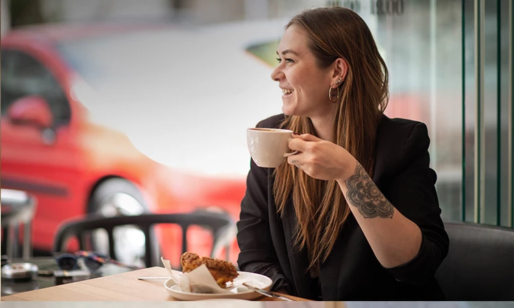 woman holding coffee smiling