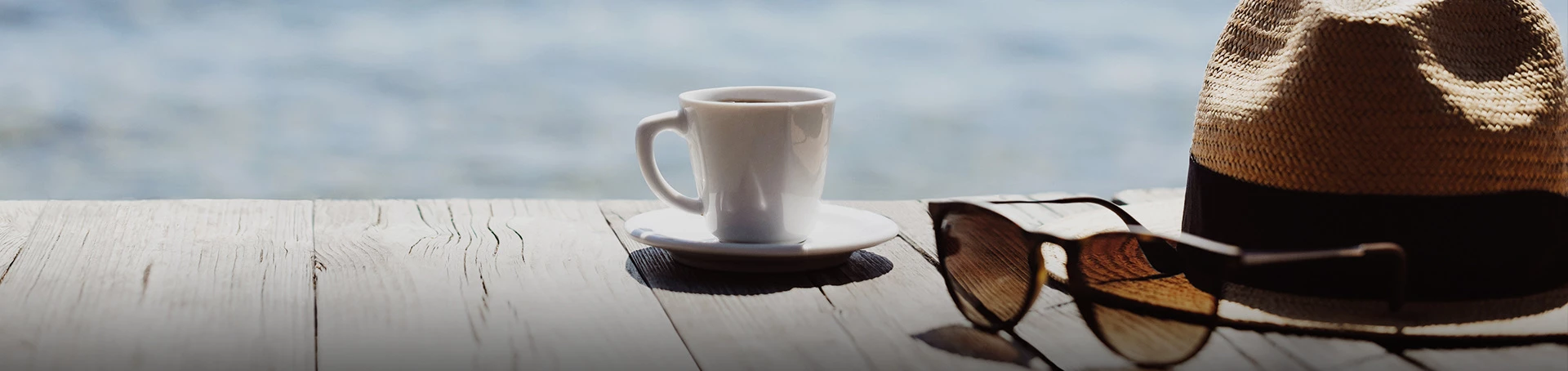 coffee, sunglasses, and sun hat on a deck