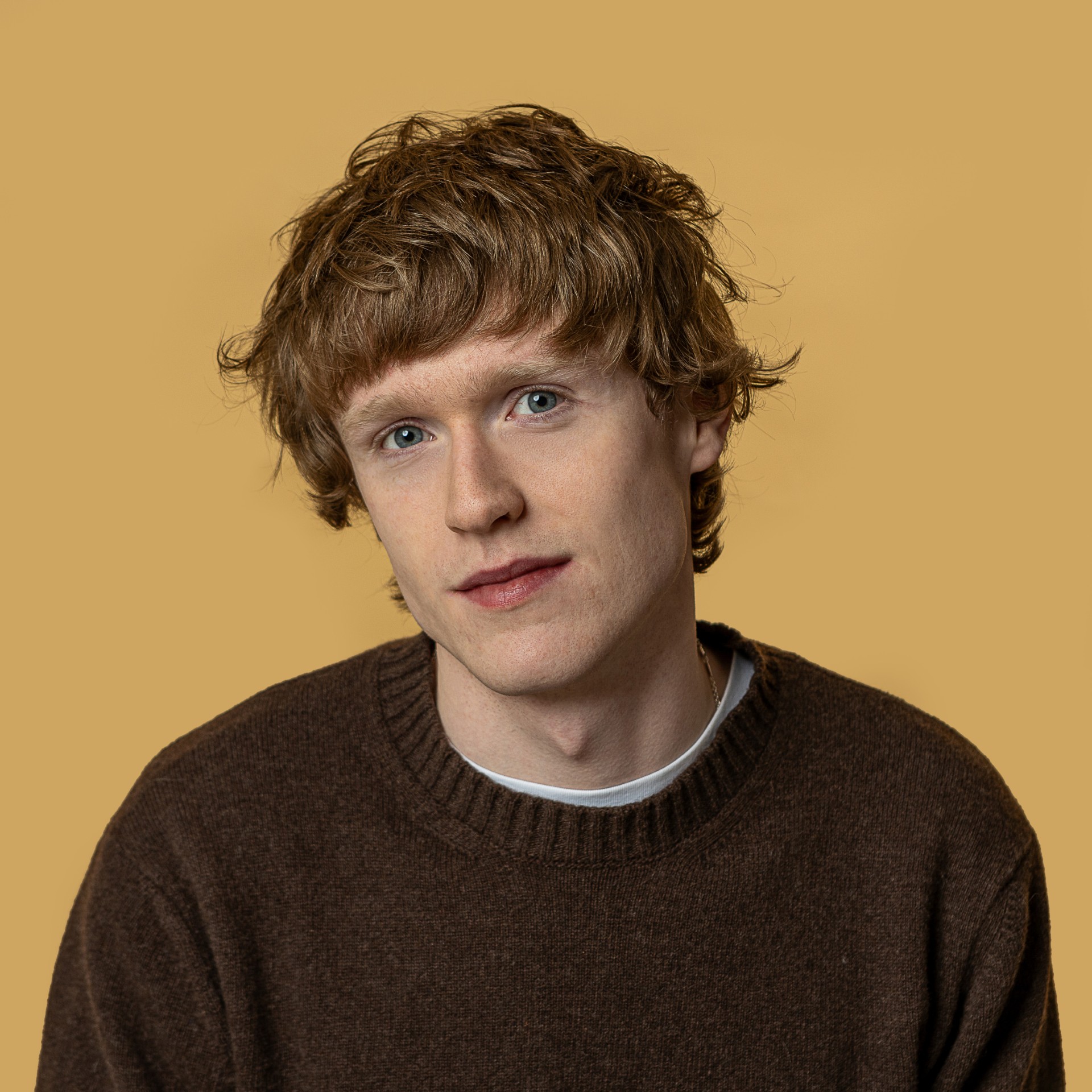 a man in a brown sweater