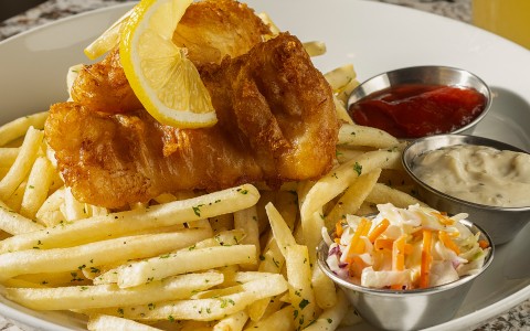 a plate of food with sauces and a glass of beer