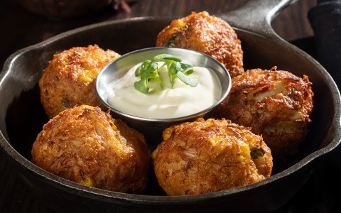 a pan of food with a small bowl of sauce