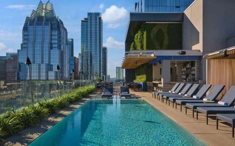 a pool with chairs and a building in the background
