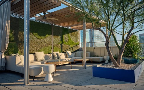 a patio with a covered area and a tree