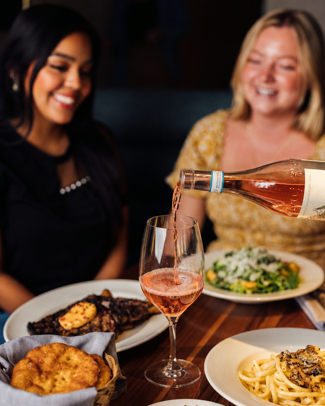a woman pouring wine into a glass