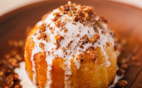 a round pastry with white frosting and crumbles on top
