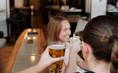 a woman holding a glass of beer
