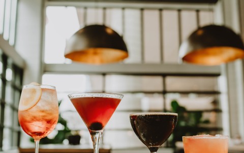 a group of glasses of different colored drinks