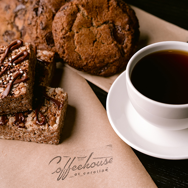 mug of espresso coffe, a chocolate cake and a cookie by the side