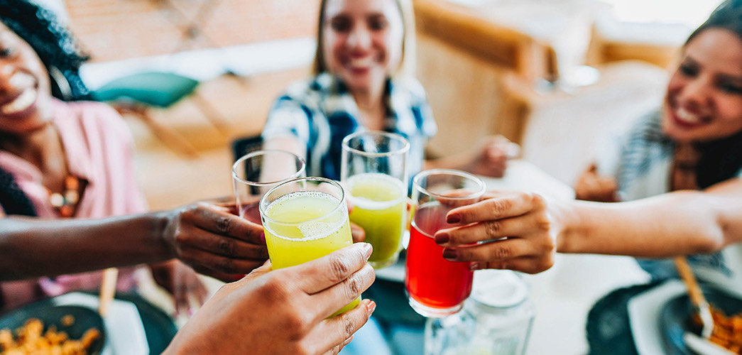 a group of people holding glasses of liquid