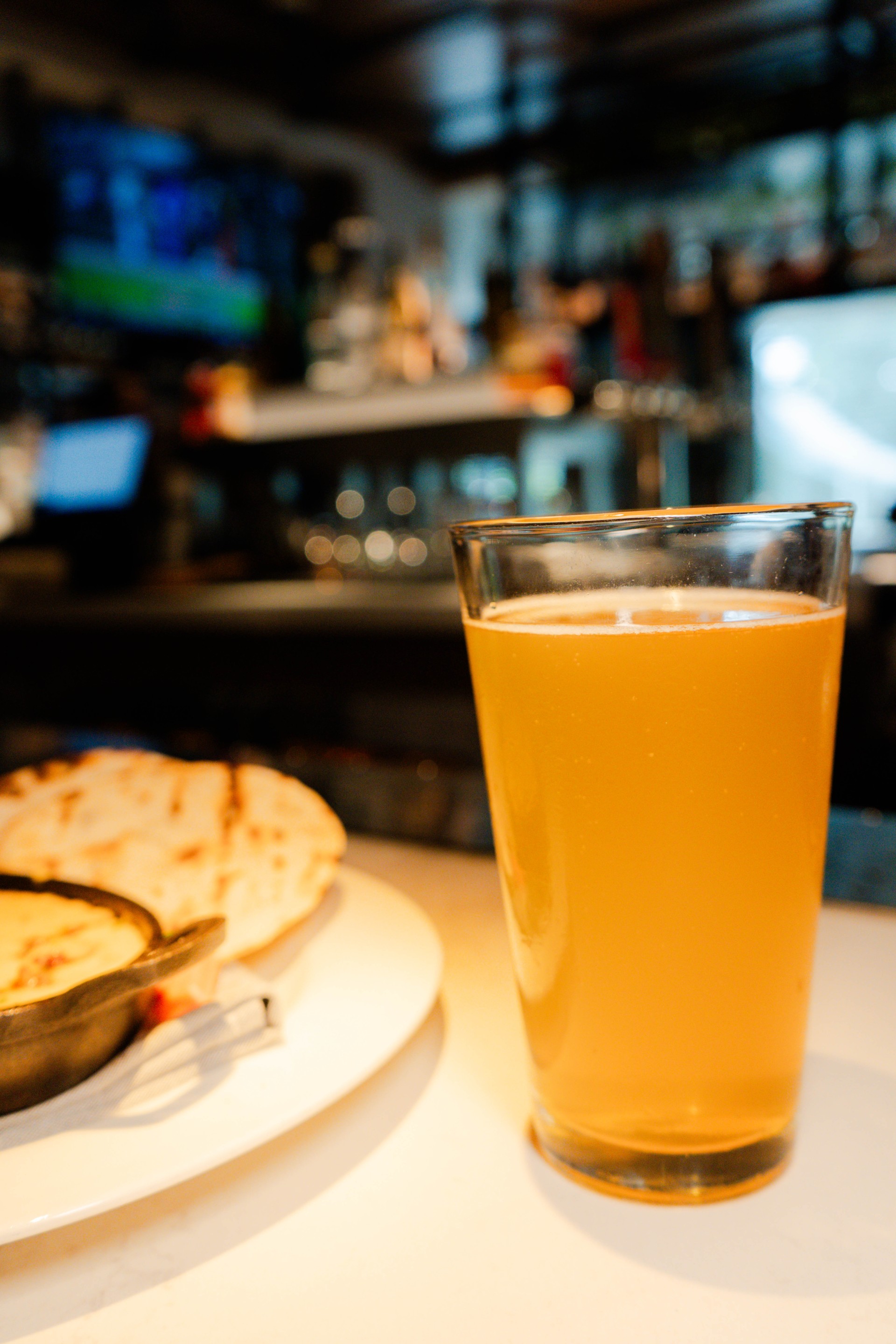 a glass of beer next to a plate of food