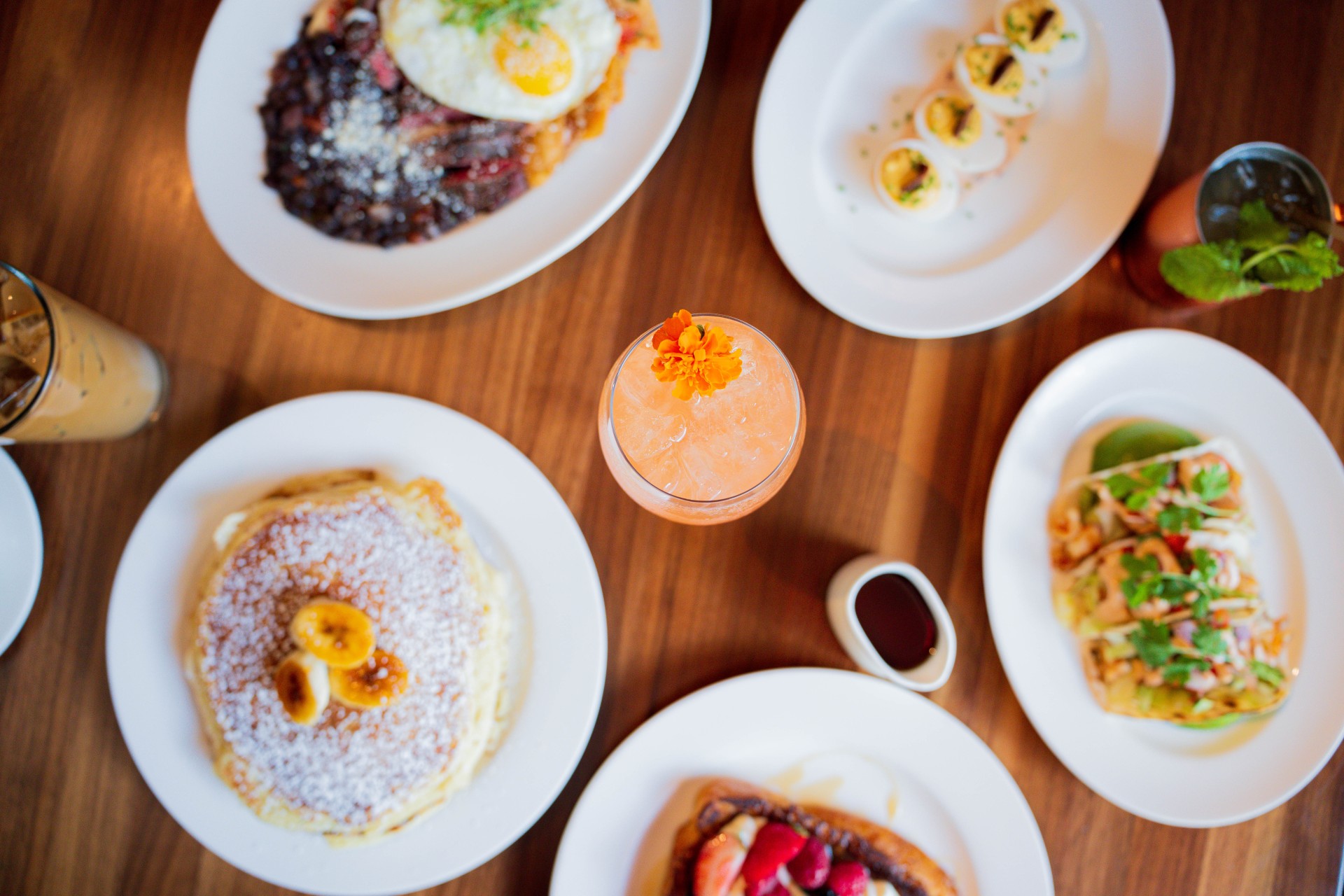 a table with plates of food and a drink