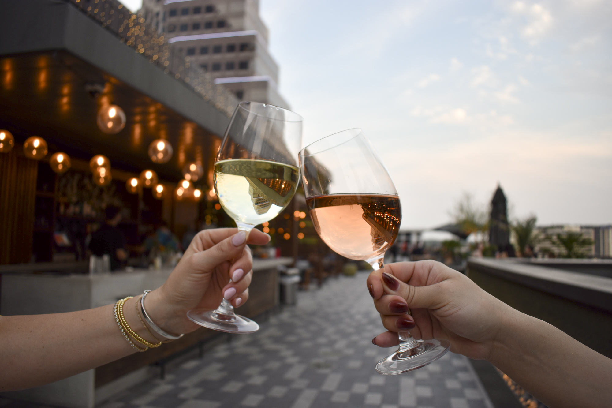 a pair of hands holding wine glasses