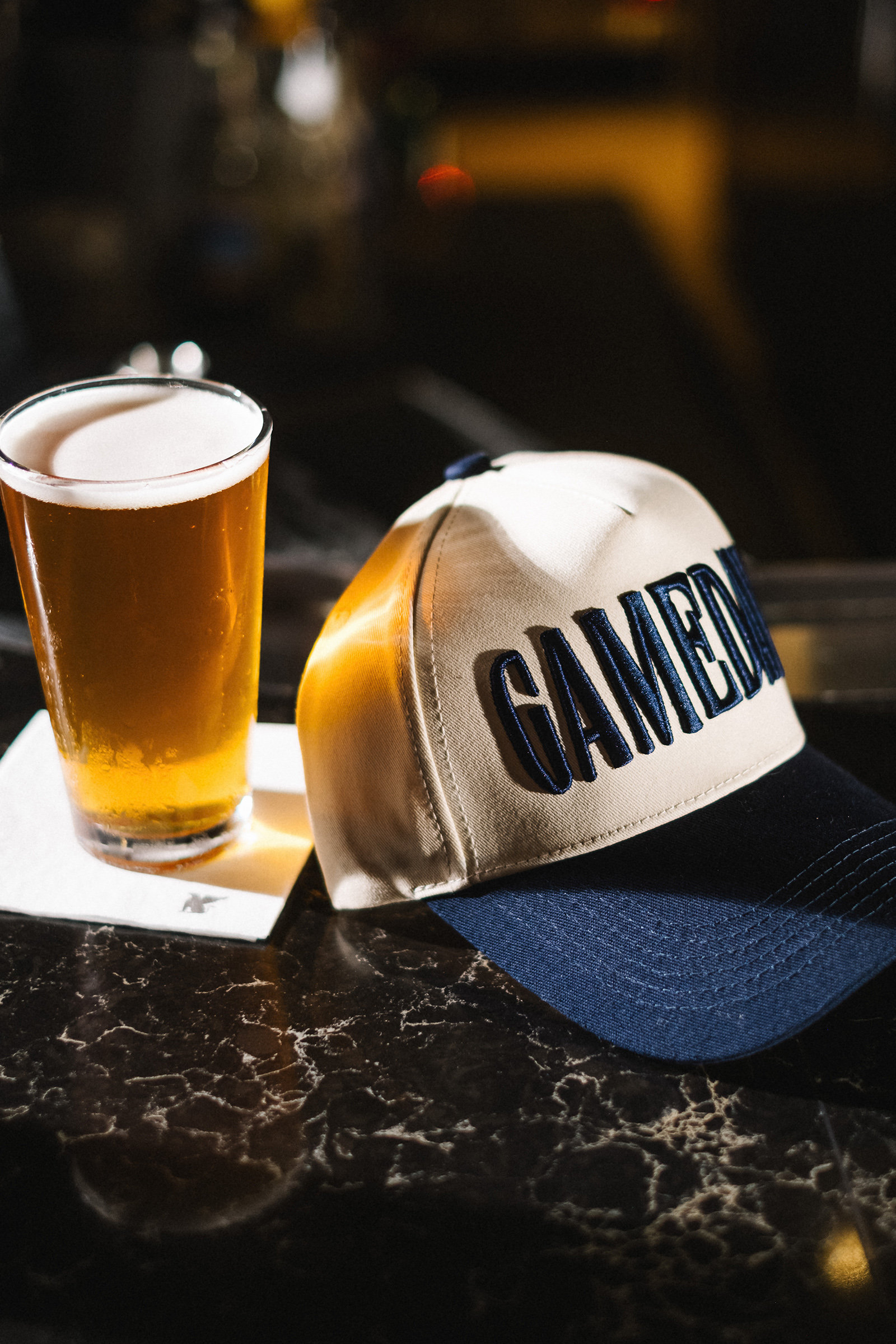 a hat and glass of beer on a table