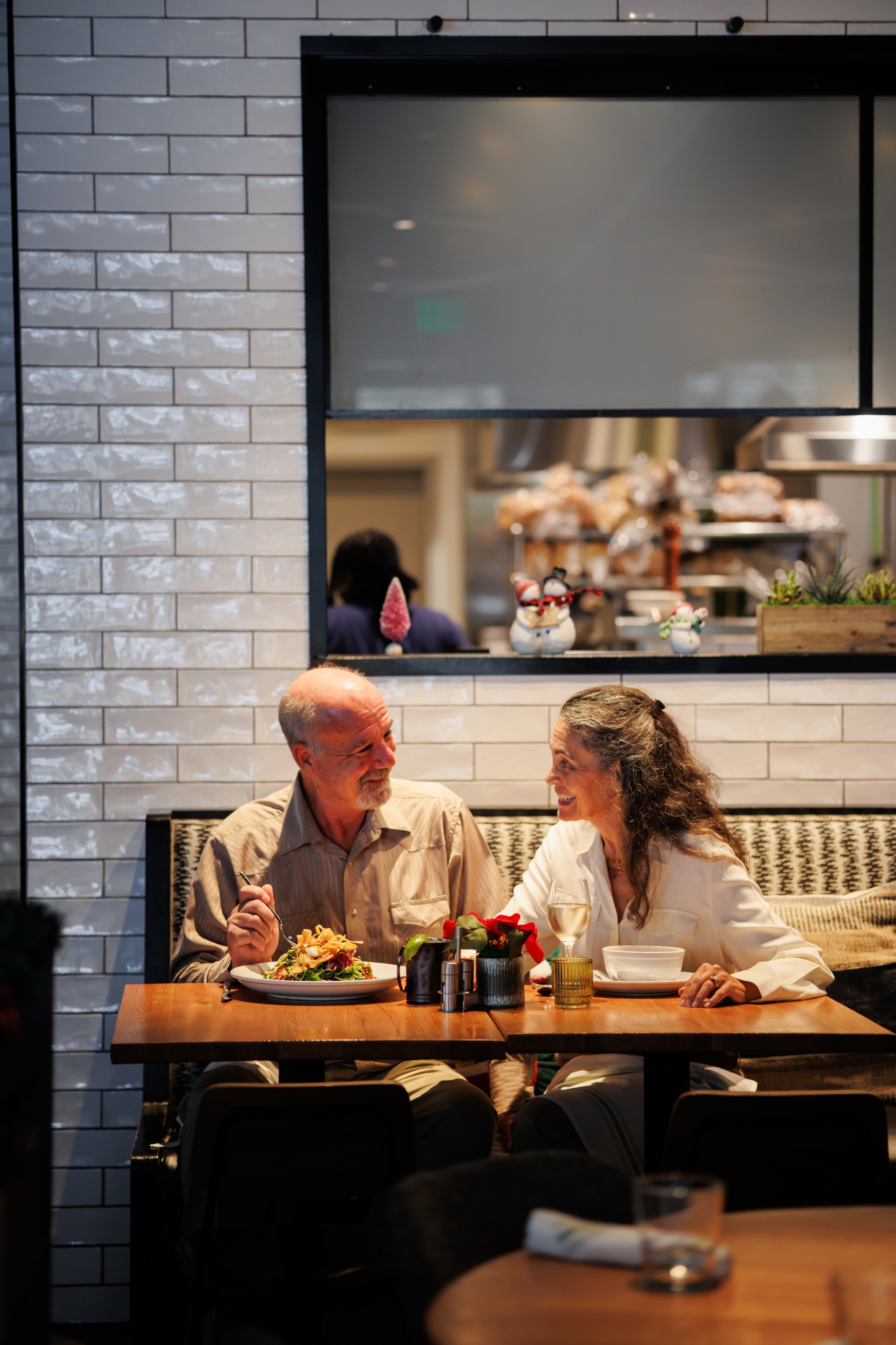 a man and woman sitting at a table with food