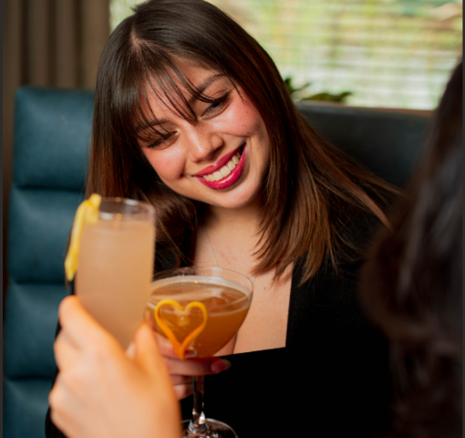 a woman smiling holding a drink