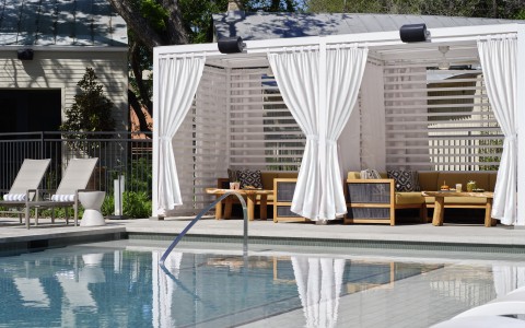 a pool with a white tent and chairs