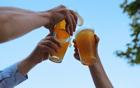 a group of people clinking glasses of beer