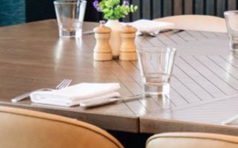 a table with a glass and salt shaker