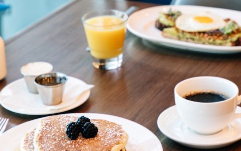 a plate of pancakes and coffee on a table main