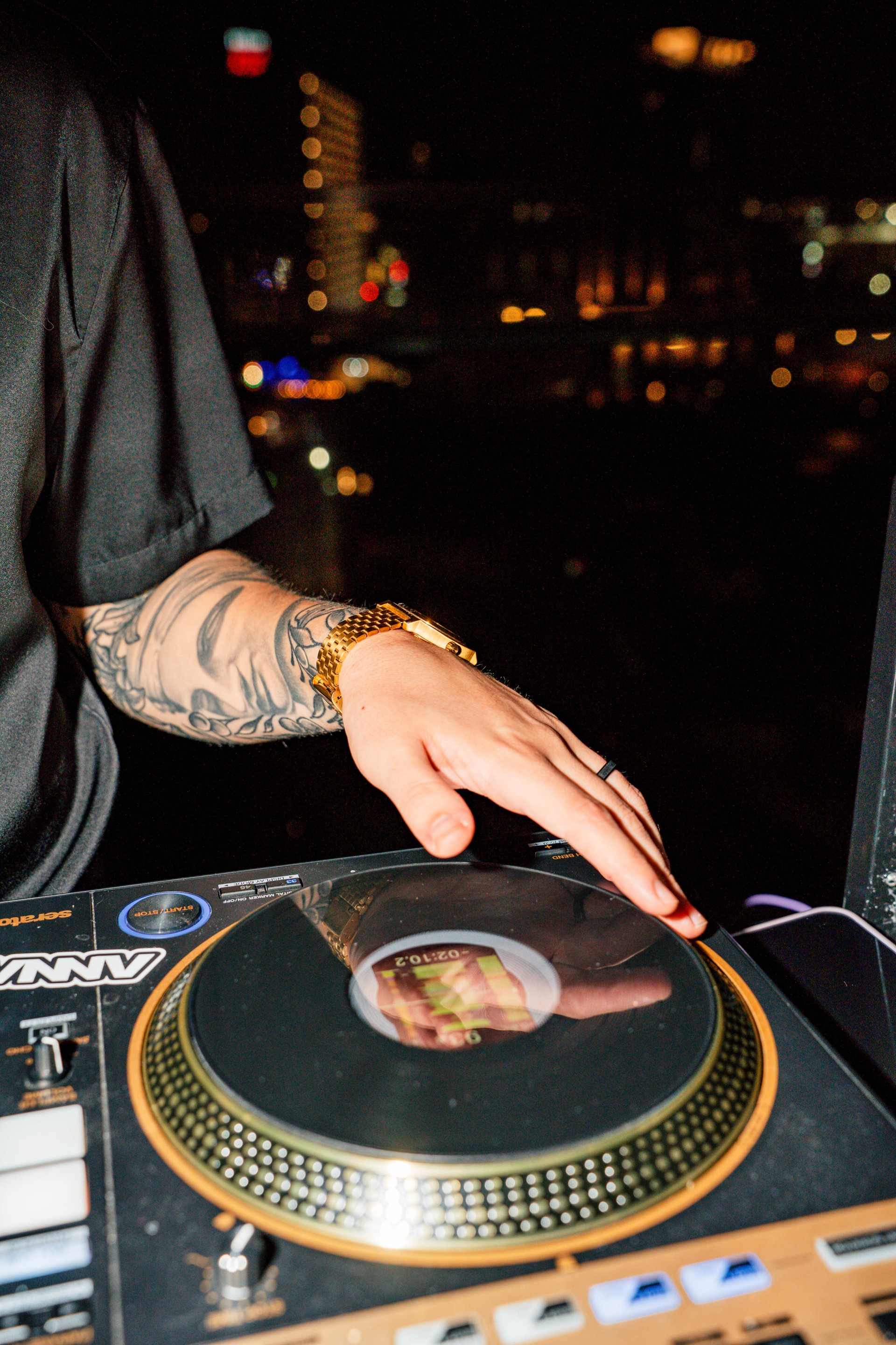 a person with tattoos on their arm and a record player