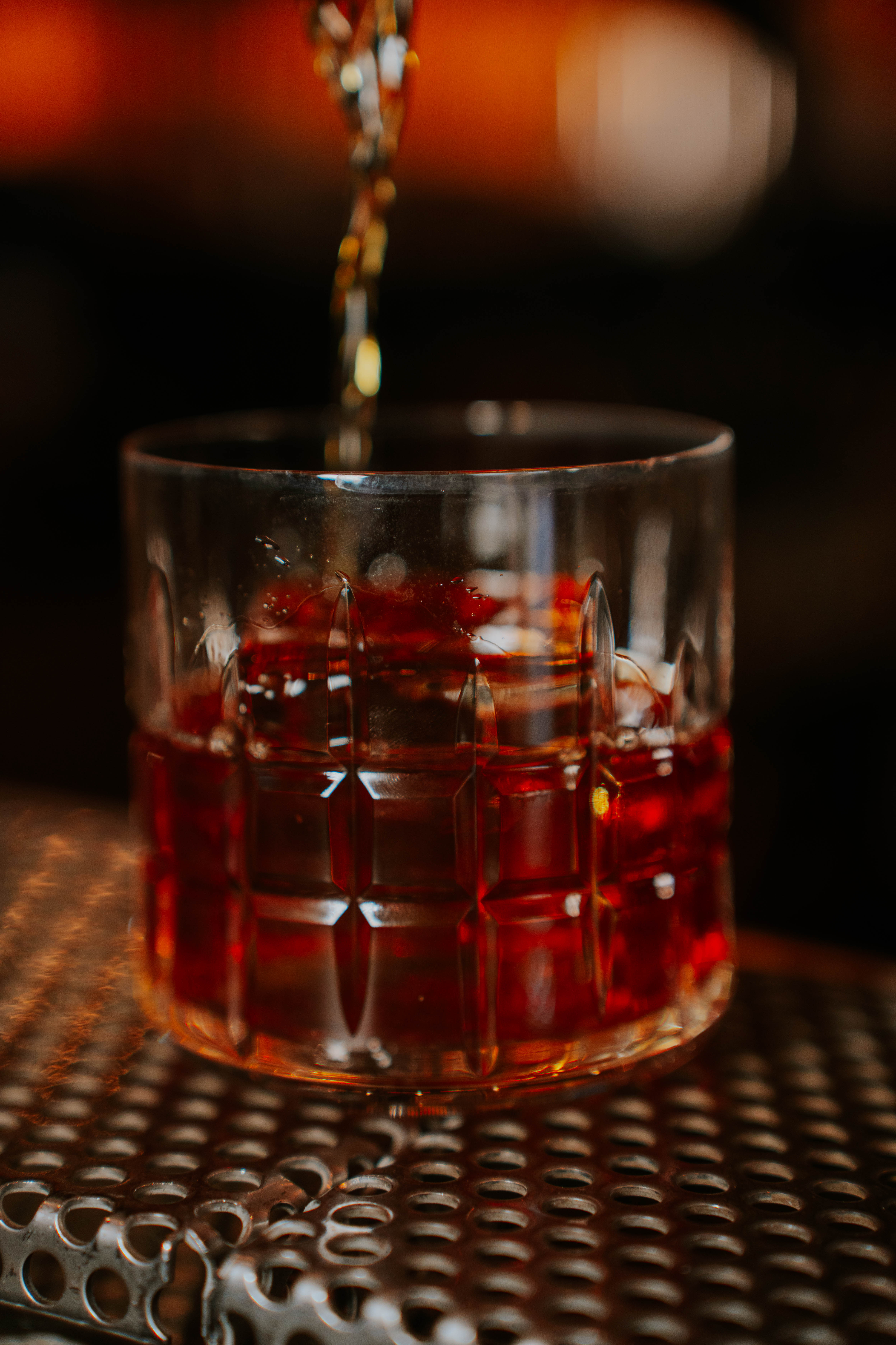 a glass with a drink being poured