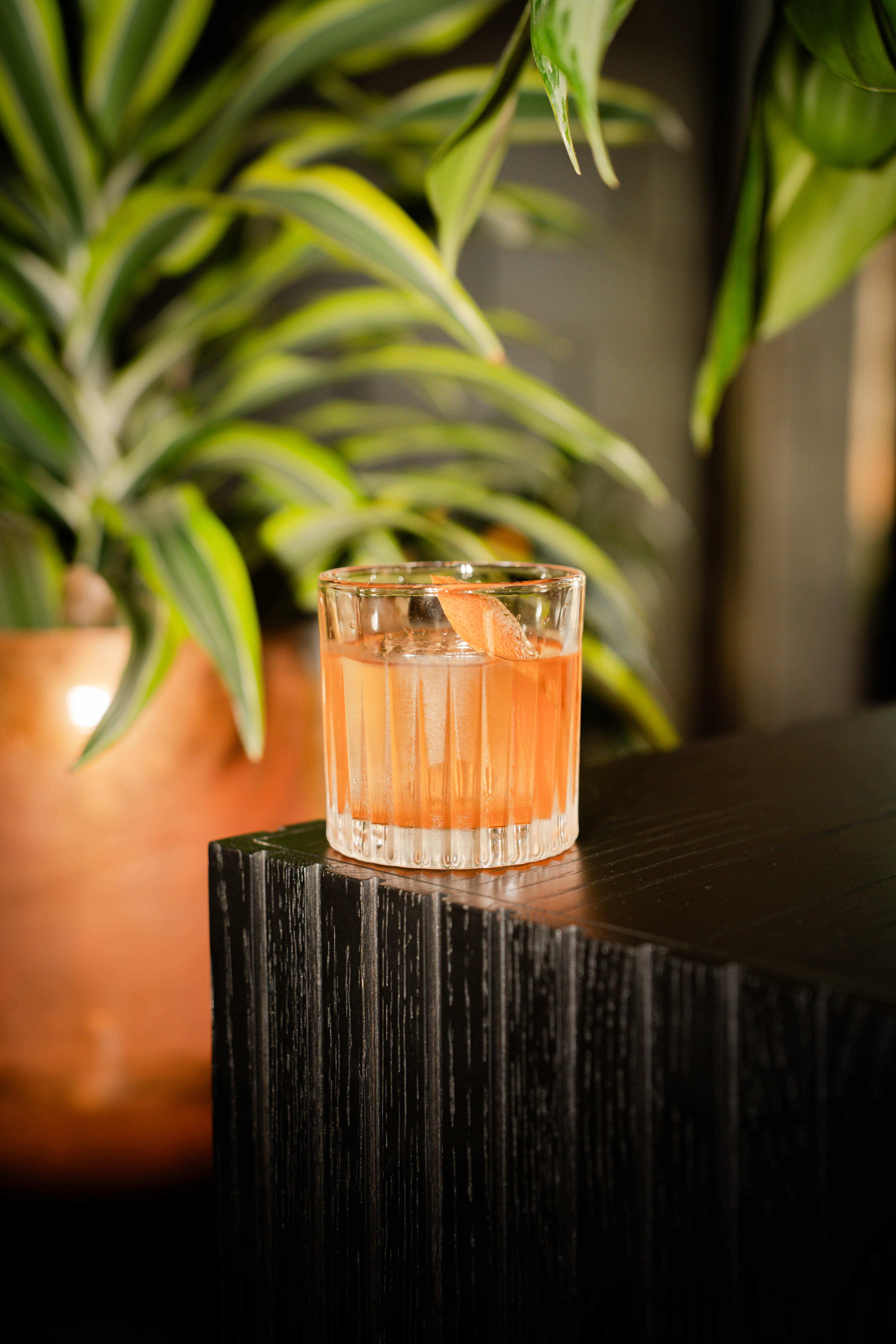 a glass of liquid on a black surface