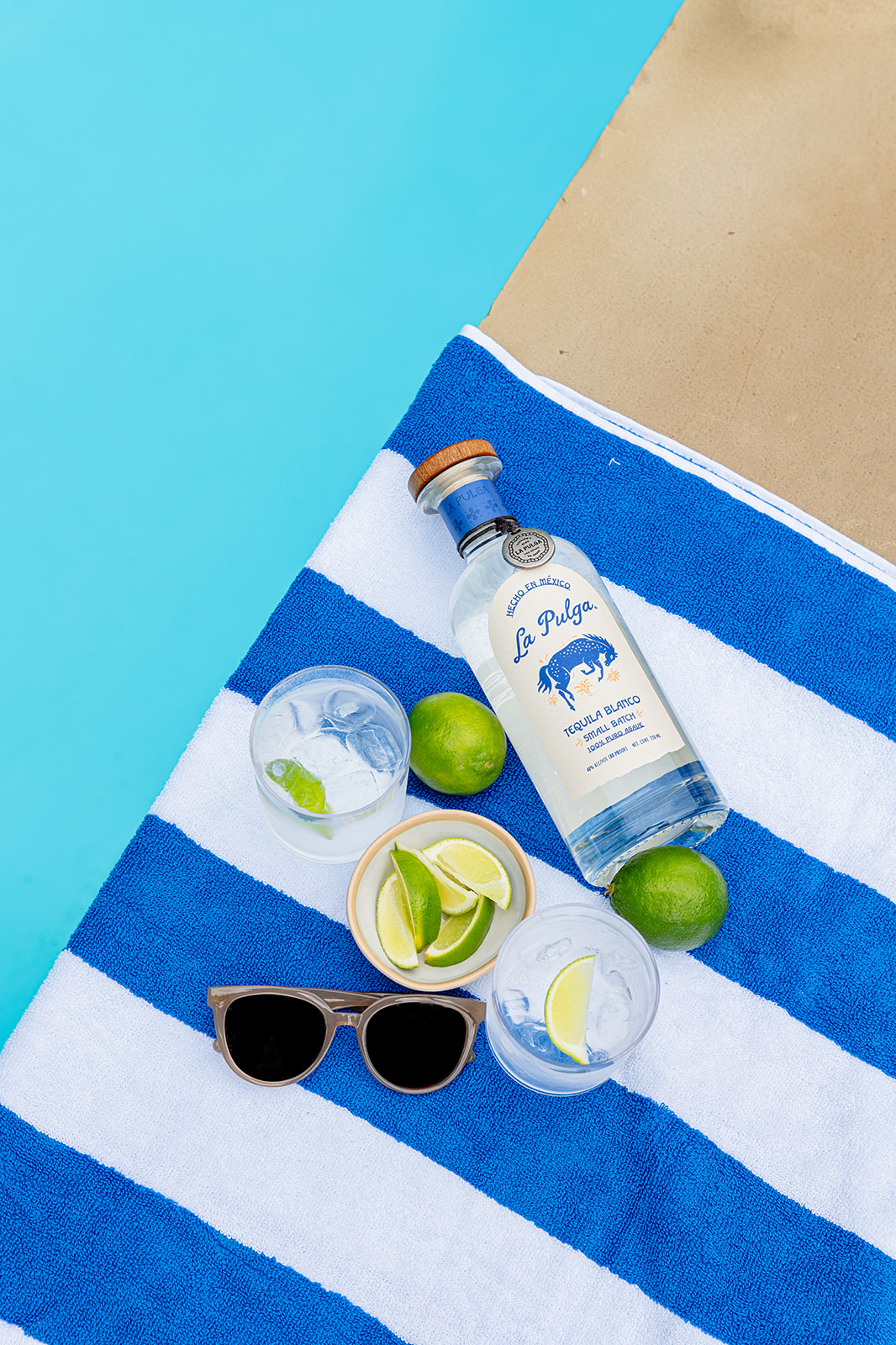 a bottle of tequila and glasses on a towel