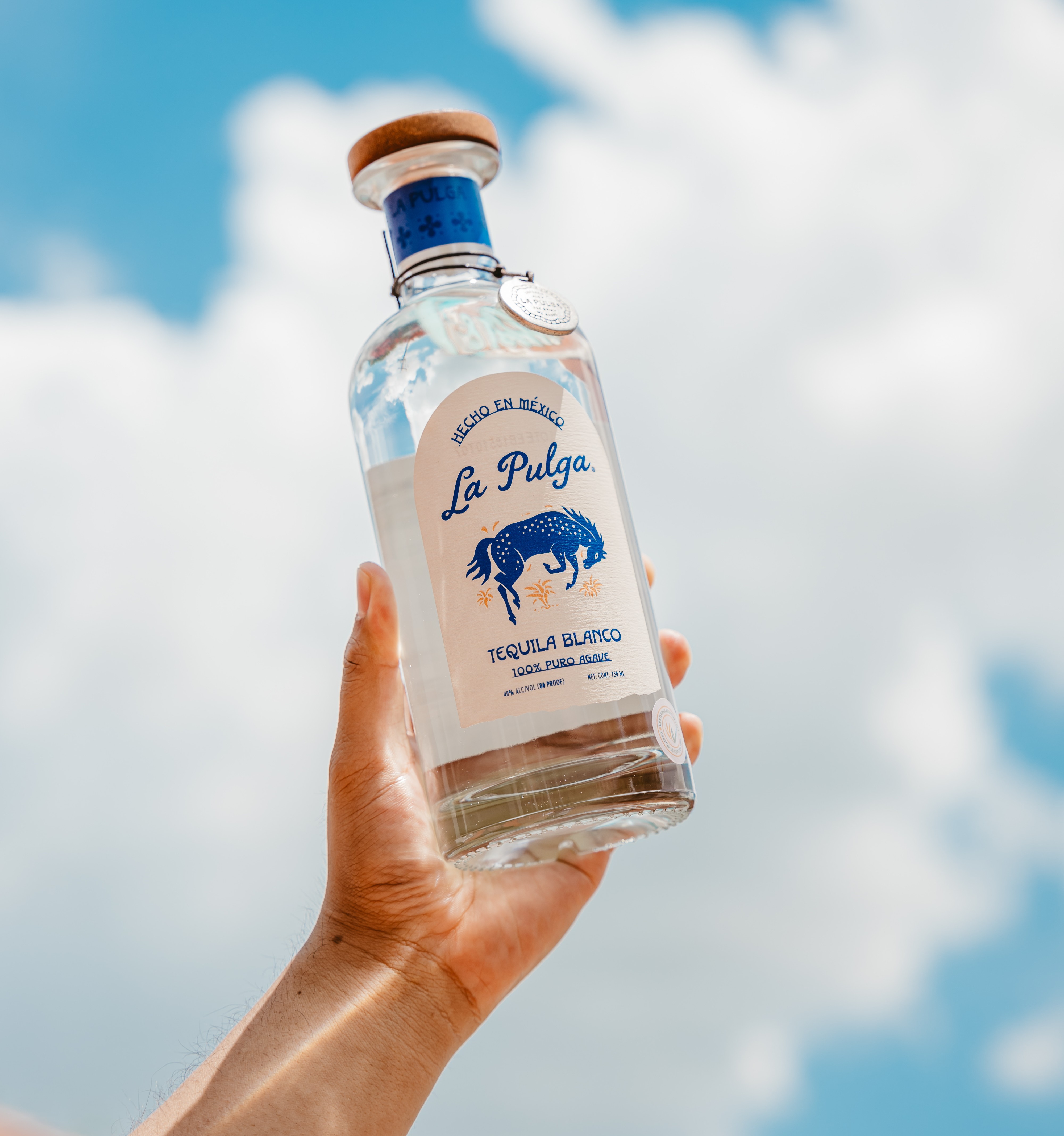 a hand holding a bottle of alcohol