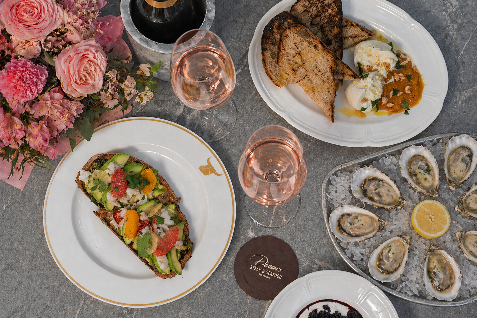 a table with plates of food and wine glasses