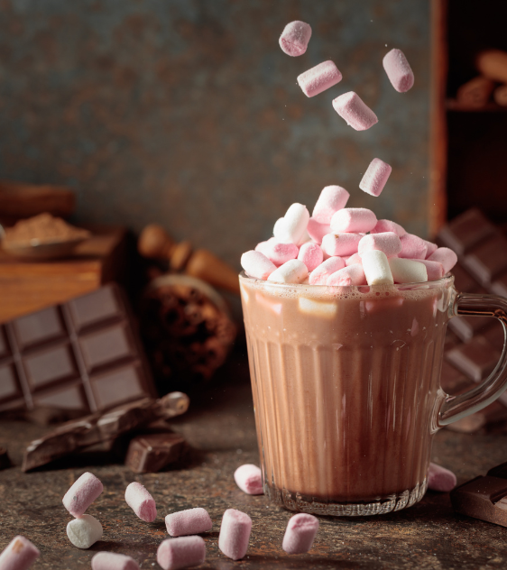 a cup of hot chocolate with marshmallows falling