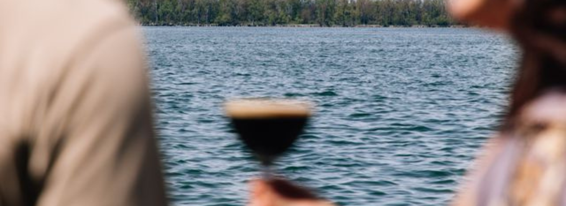 a hand holding a glass of liquid
