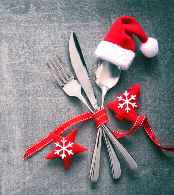 a fork and knife with a santa hat and red ribbon