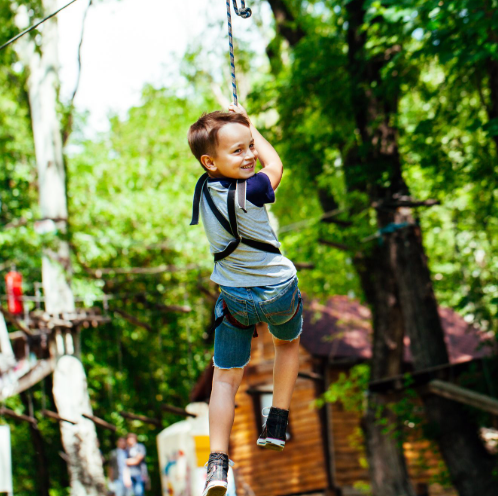 a boy in a harness on a zip line