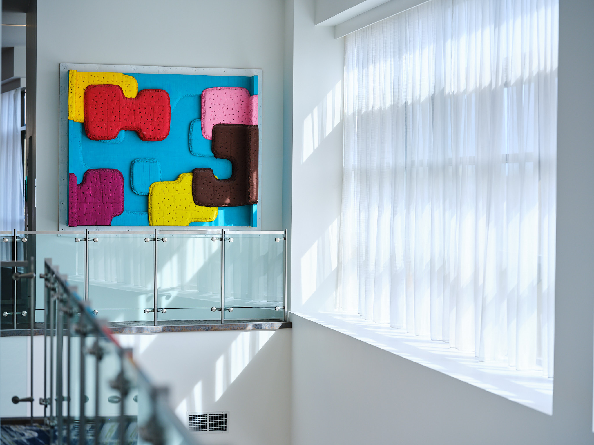 a room with a wall art and a railing