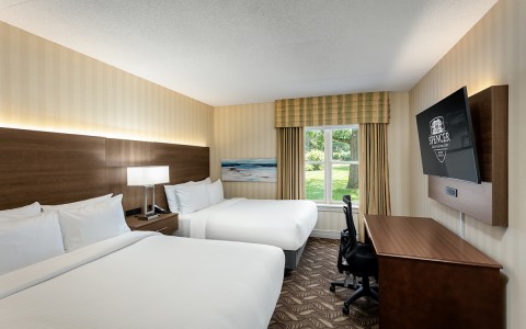 a room with two beds and a desk