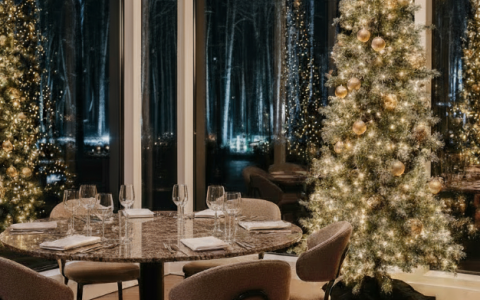 a table with a tree and chairs in front of a window