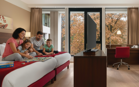 a family sitting on a bed in a hotel room