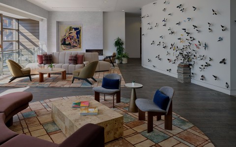 a room with a large wall with many chairs and a couch