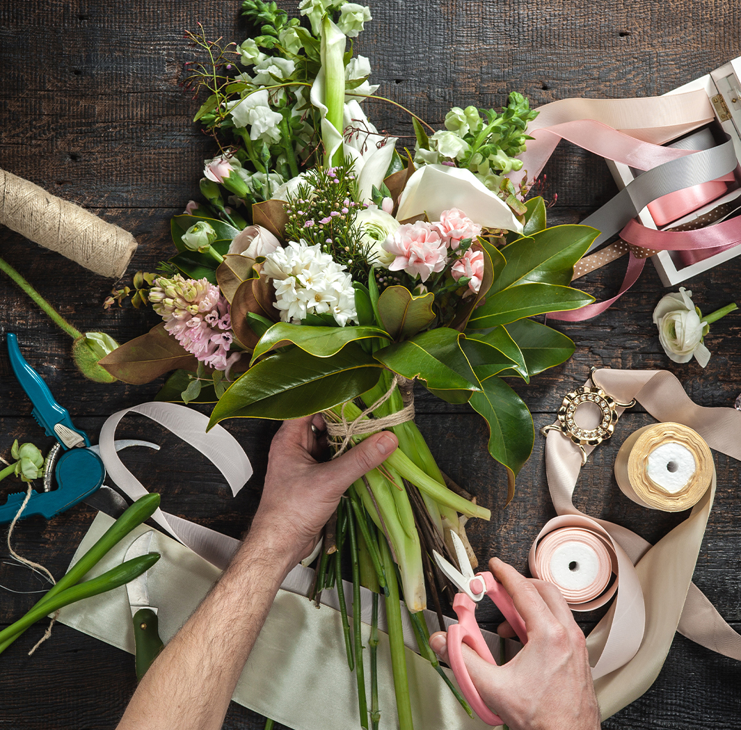 a person's hands holding a bouquet of flowers