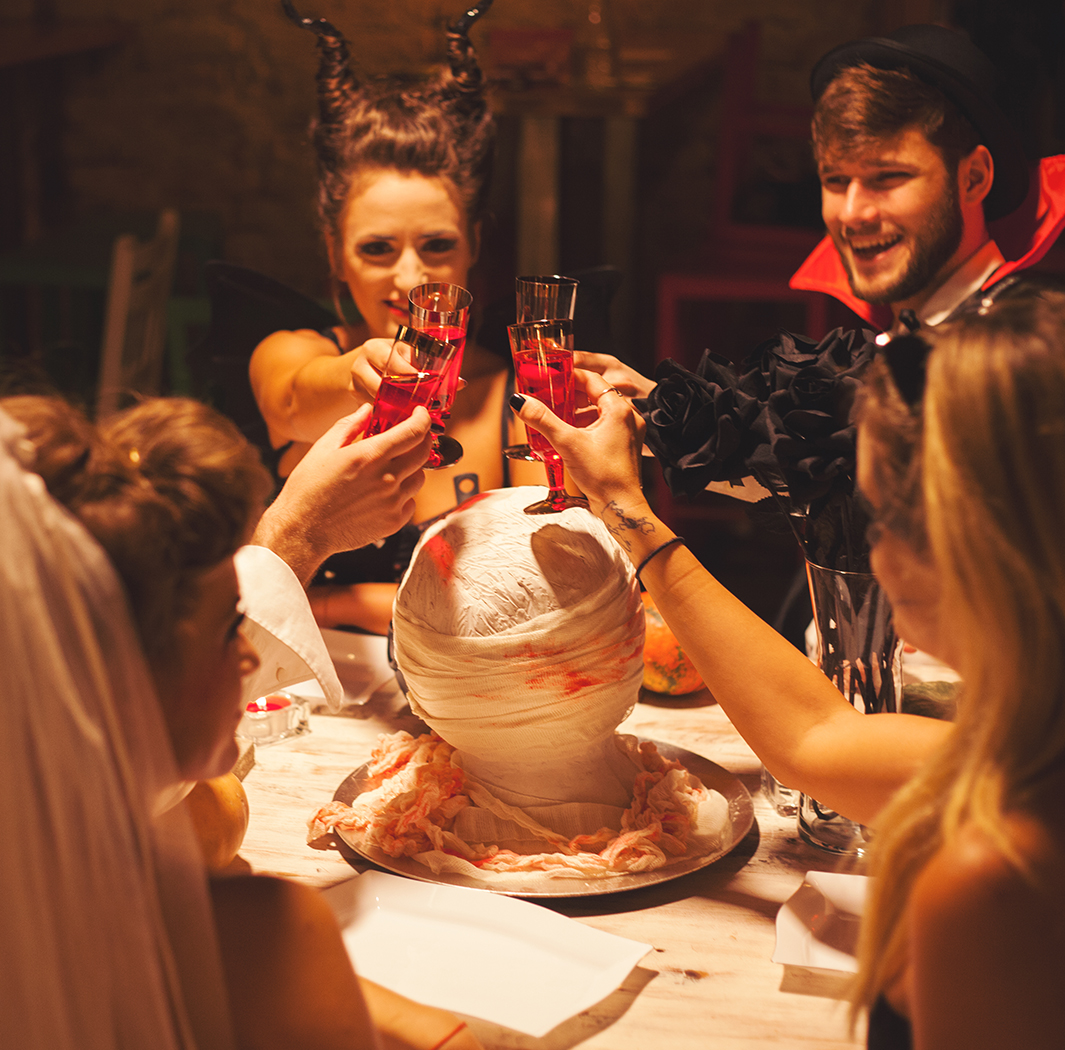 a group of people in clothing at a table with drinks