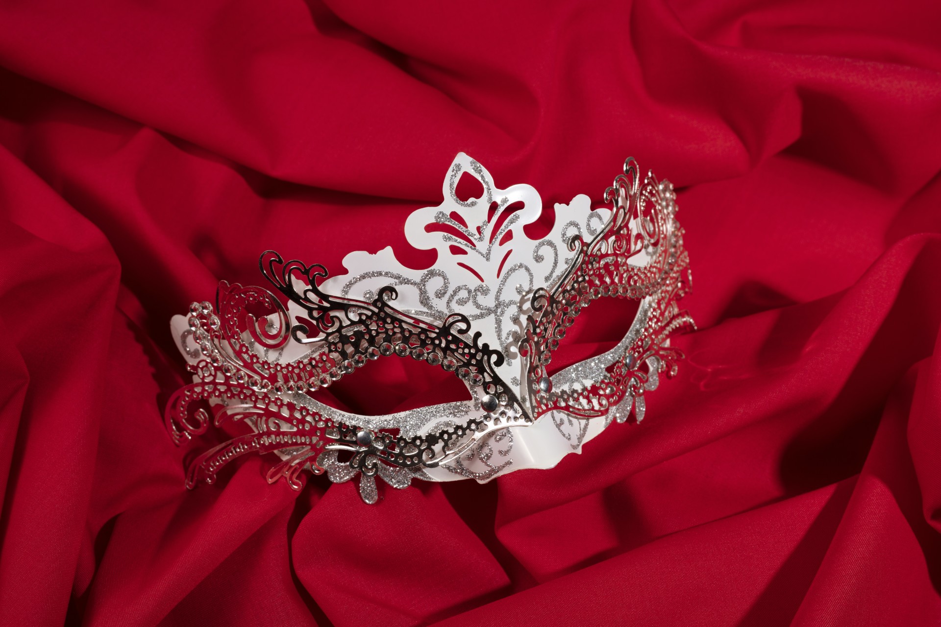 a white and black mask on a red fabric