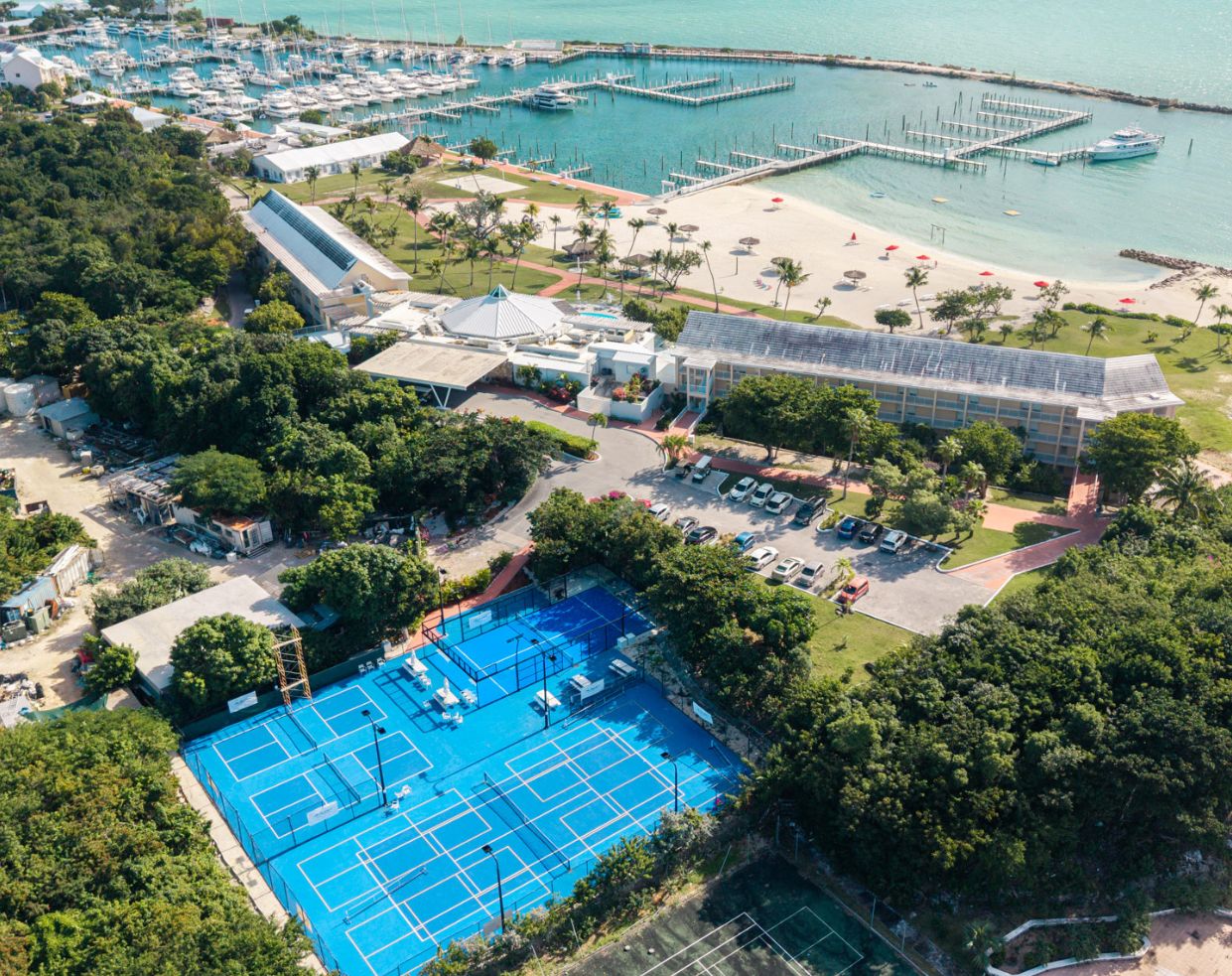 a tennis court and a beach with boats and water