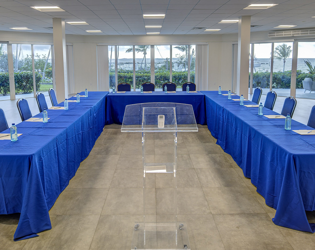 a room with a podium and blue tables