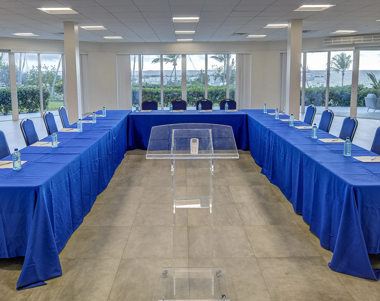 a room with a podium and blue tables