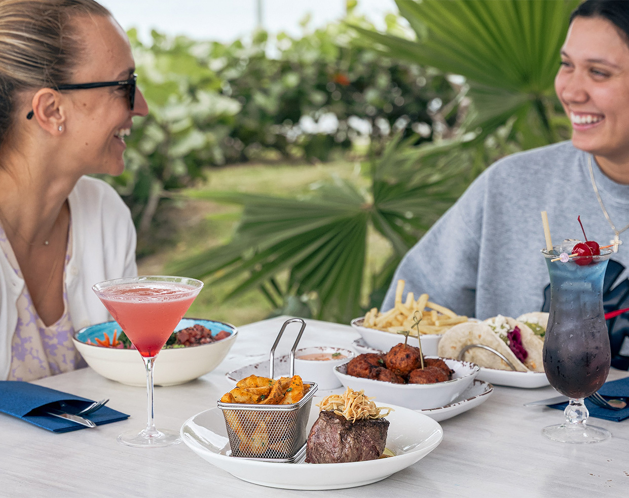 a couple of people sitting at a table with food