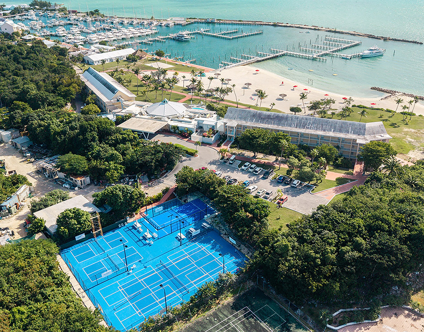 a tennis court and a beach with boats and water