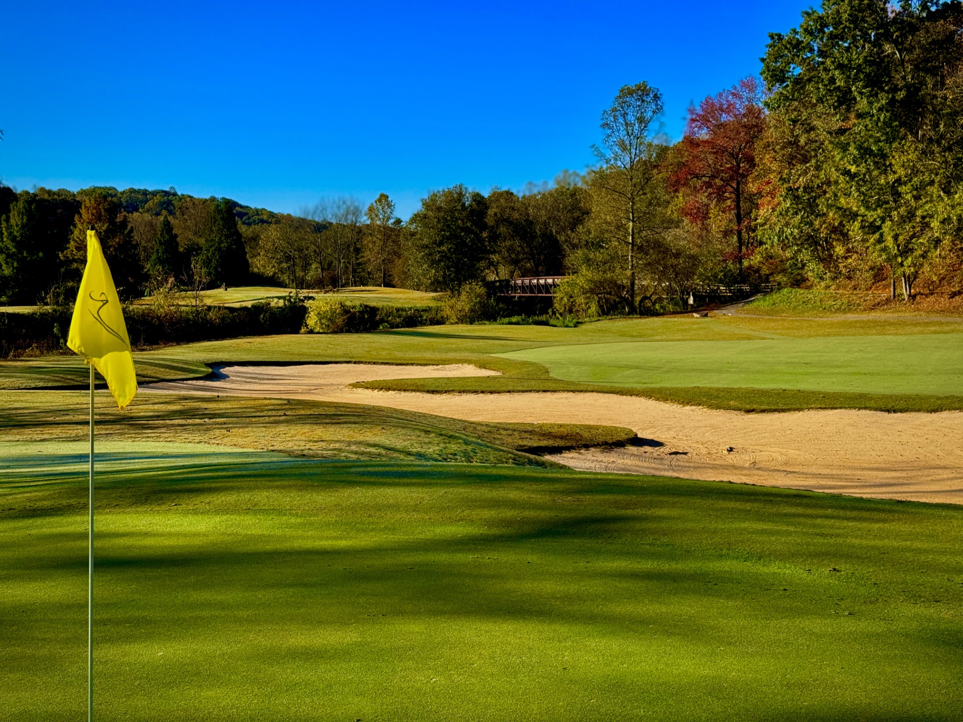 a golf course with a yellow flag