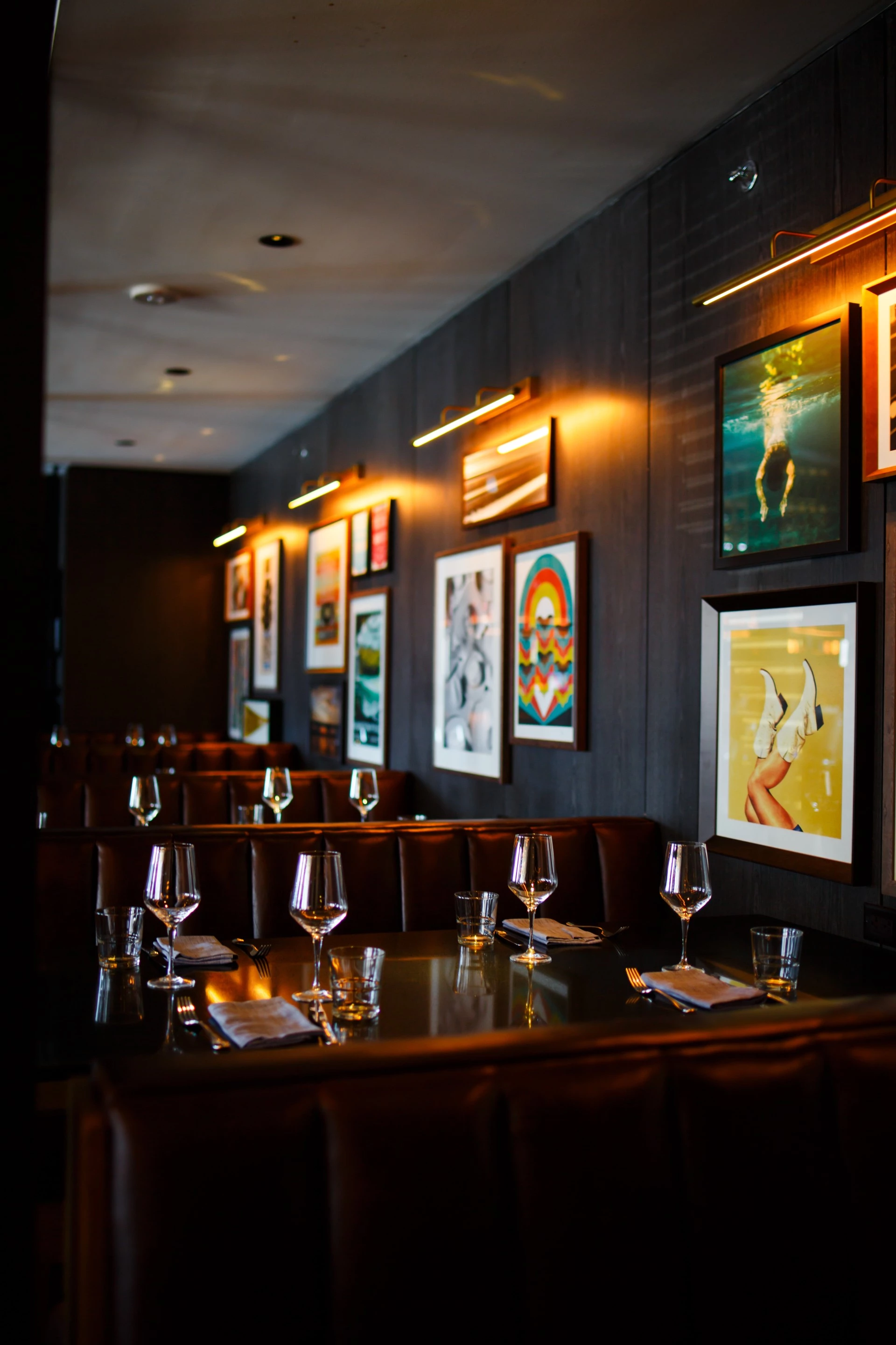 a restaurant with a booth and table set with wine glasses