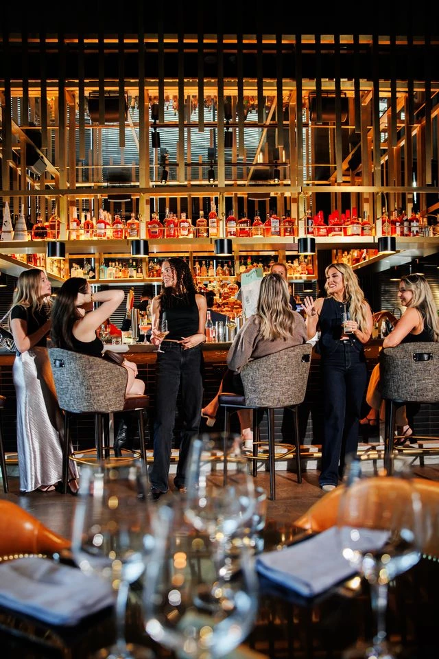 a group of women sitting at a bar