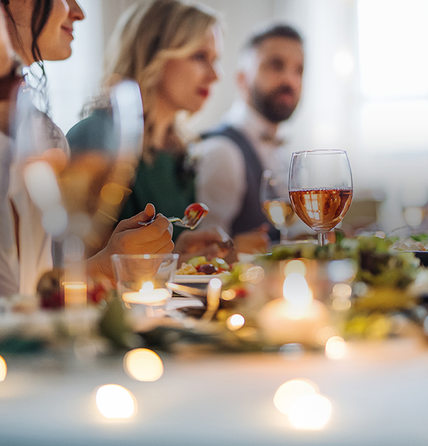 a group of people sitting at a table with food and drinks